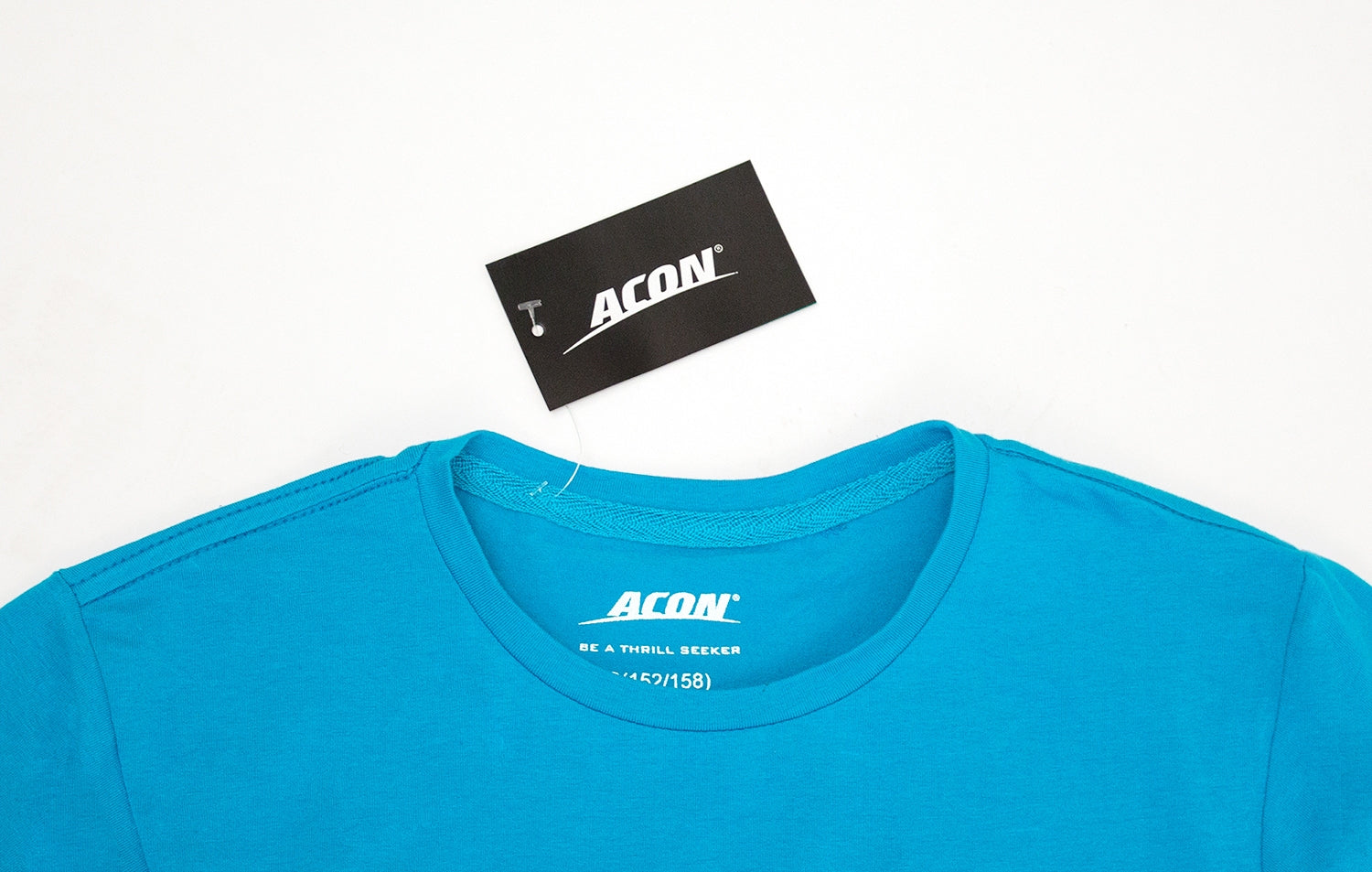 T-shirt azul com etiqueta ACON em fundo branco