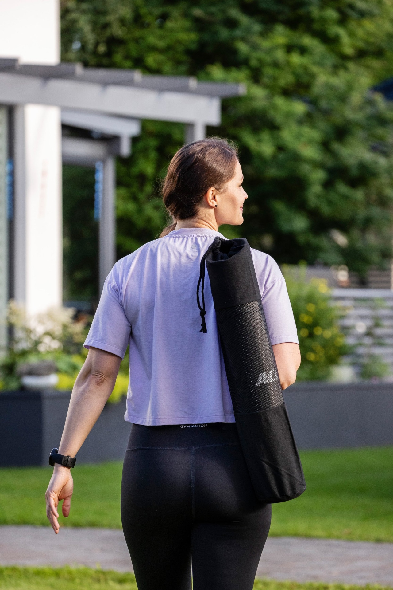 Mulher de costas roupas desportivas e tapete de yoga