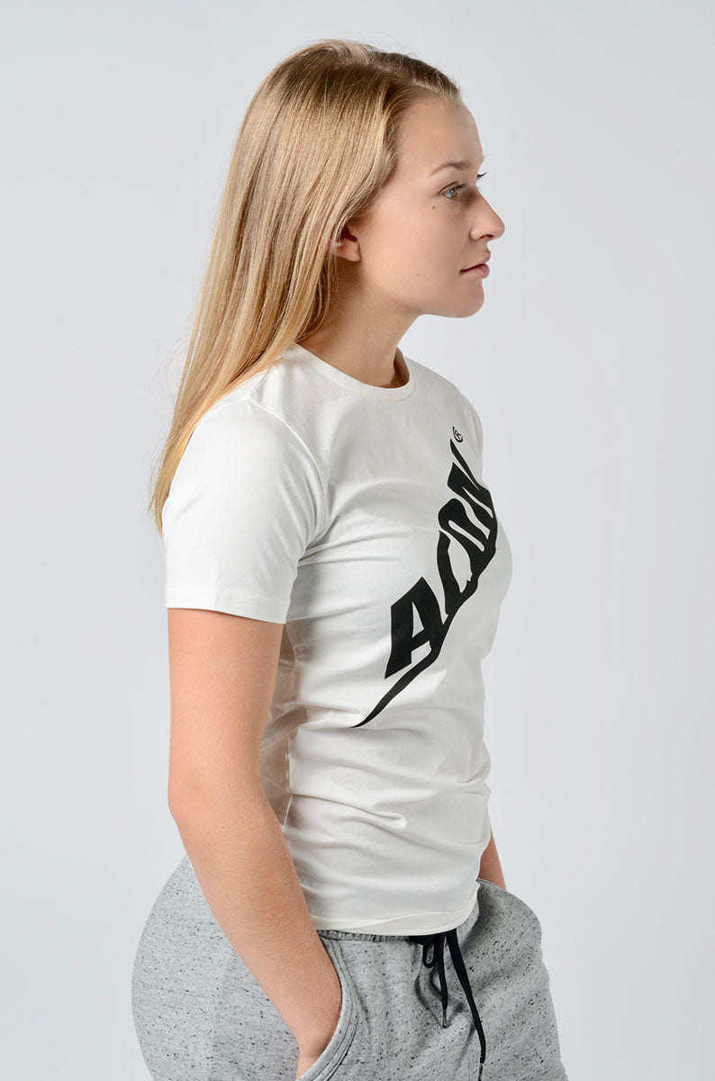 Mulher de perfil com t-shirt branca ADIDAS preta e calças cinza desportivas.