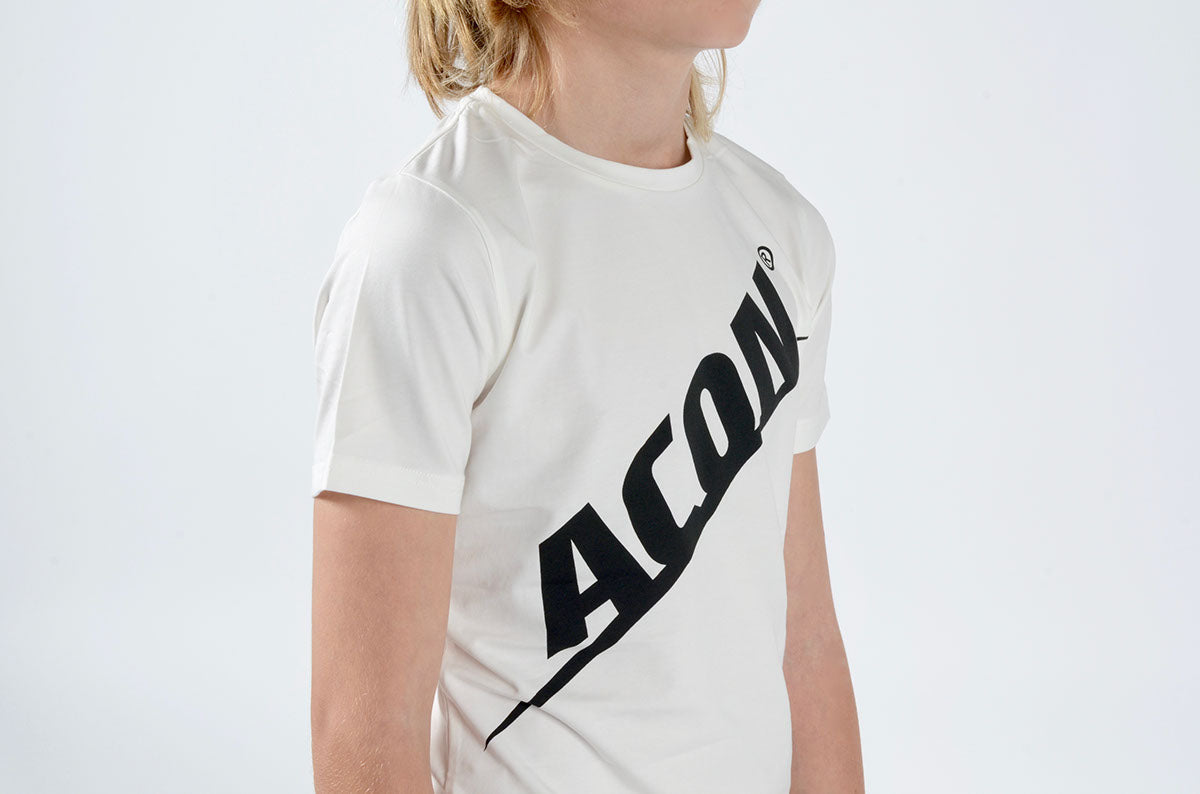 Criança com t-shirt branca e texto preto ACON