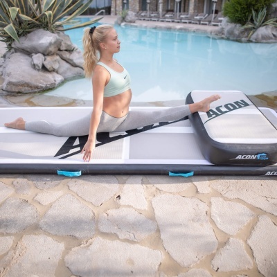 Tapete insuflável para treino cinza e branco com texto ACON junto a piscina