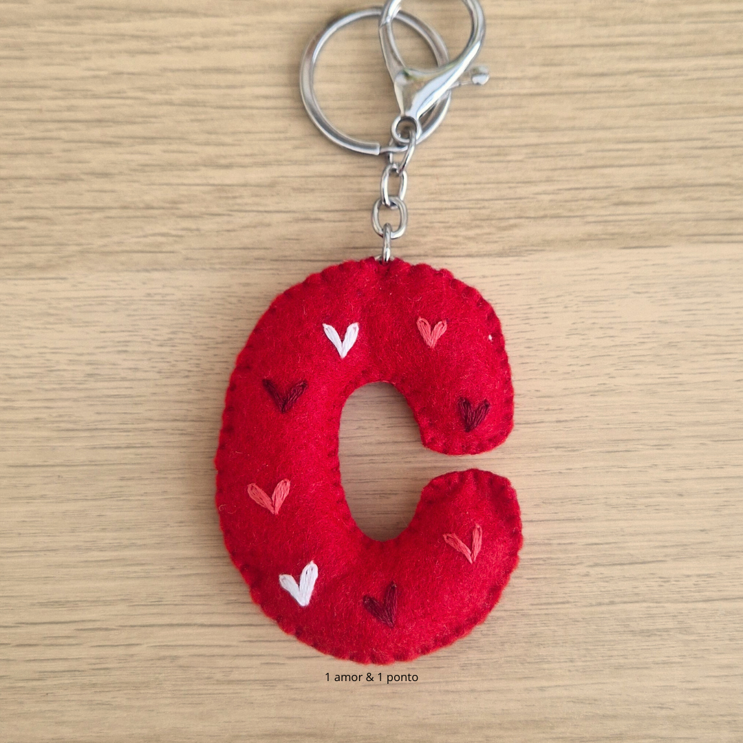 Chaveiro de tecido vermelho com bordados de corações, em forma da letra C