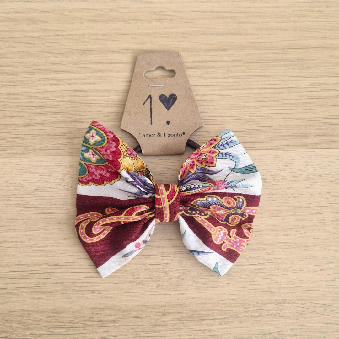 Laço colorido floral e abstracto com etiqueta sobre madeira clara