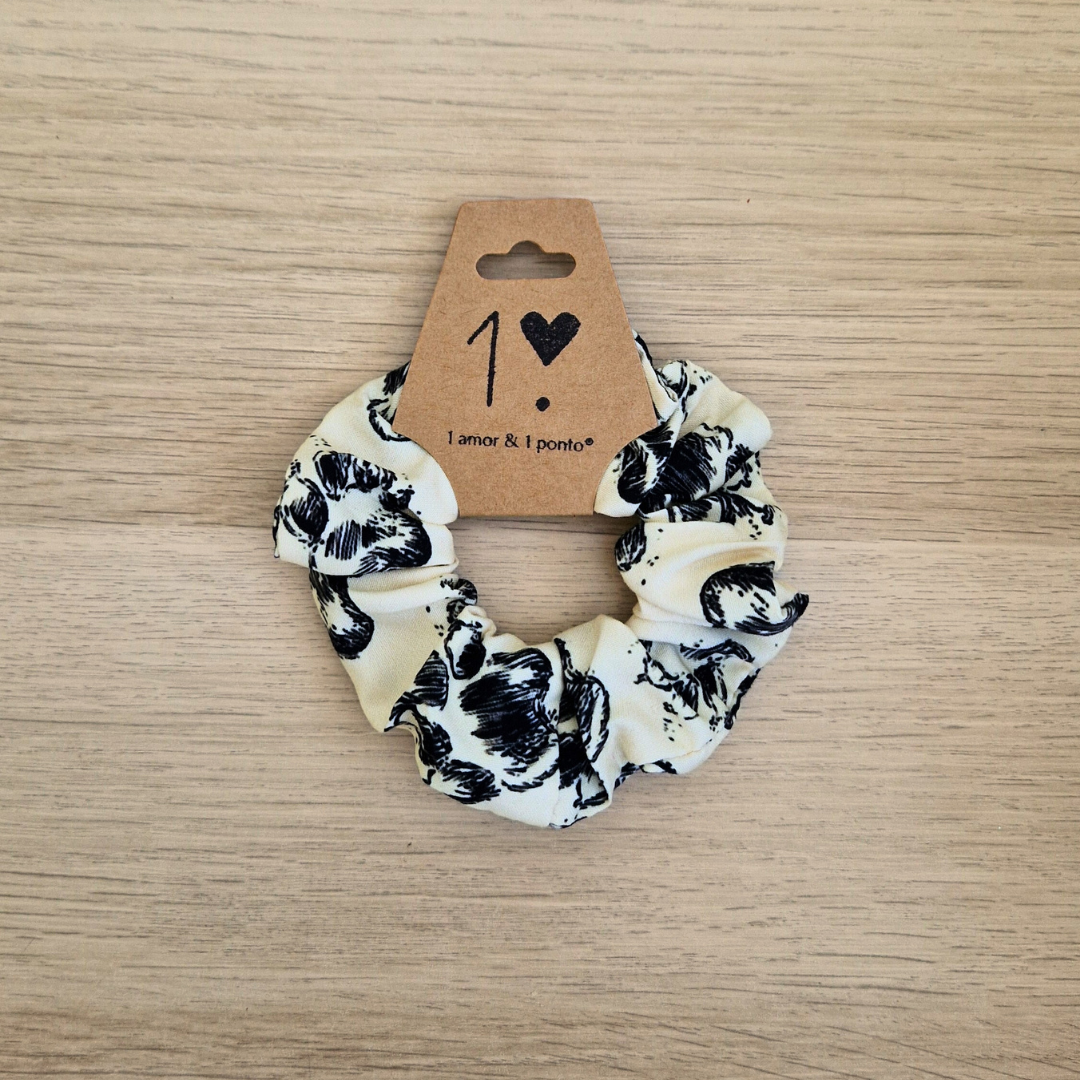 Elástico de cabelo branco com flores pretas e etiqueta marrom com texto