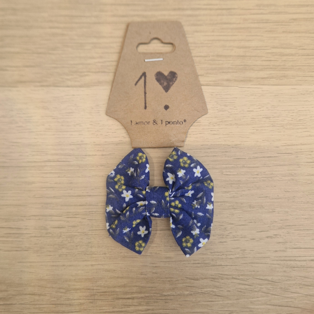 Laço para cabelo azul com flores brancas e amarelas em cartão castanho