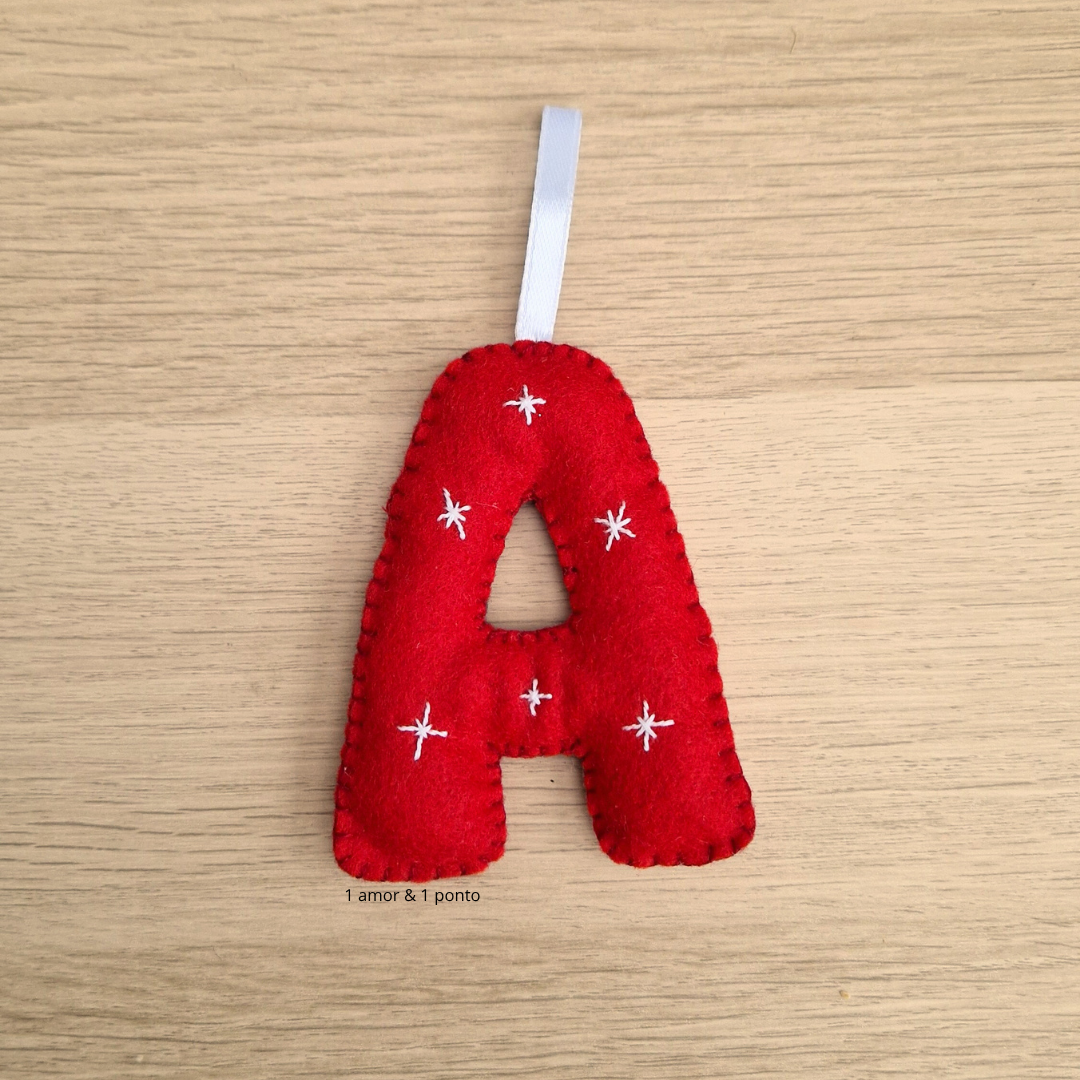 Adorno vermelho em forma da letra A com estrelas brancas bordadas