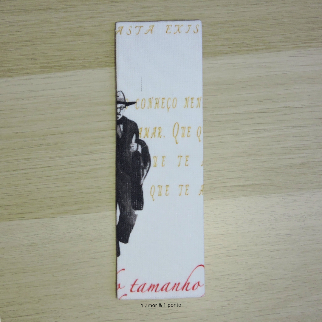 Marcador de livro branco com texto dourado e vermelho e figura humana em preto