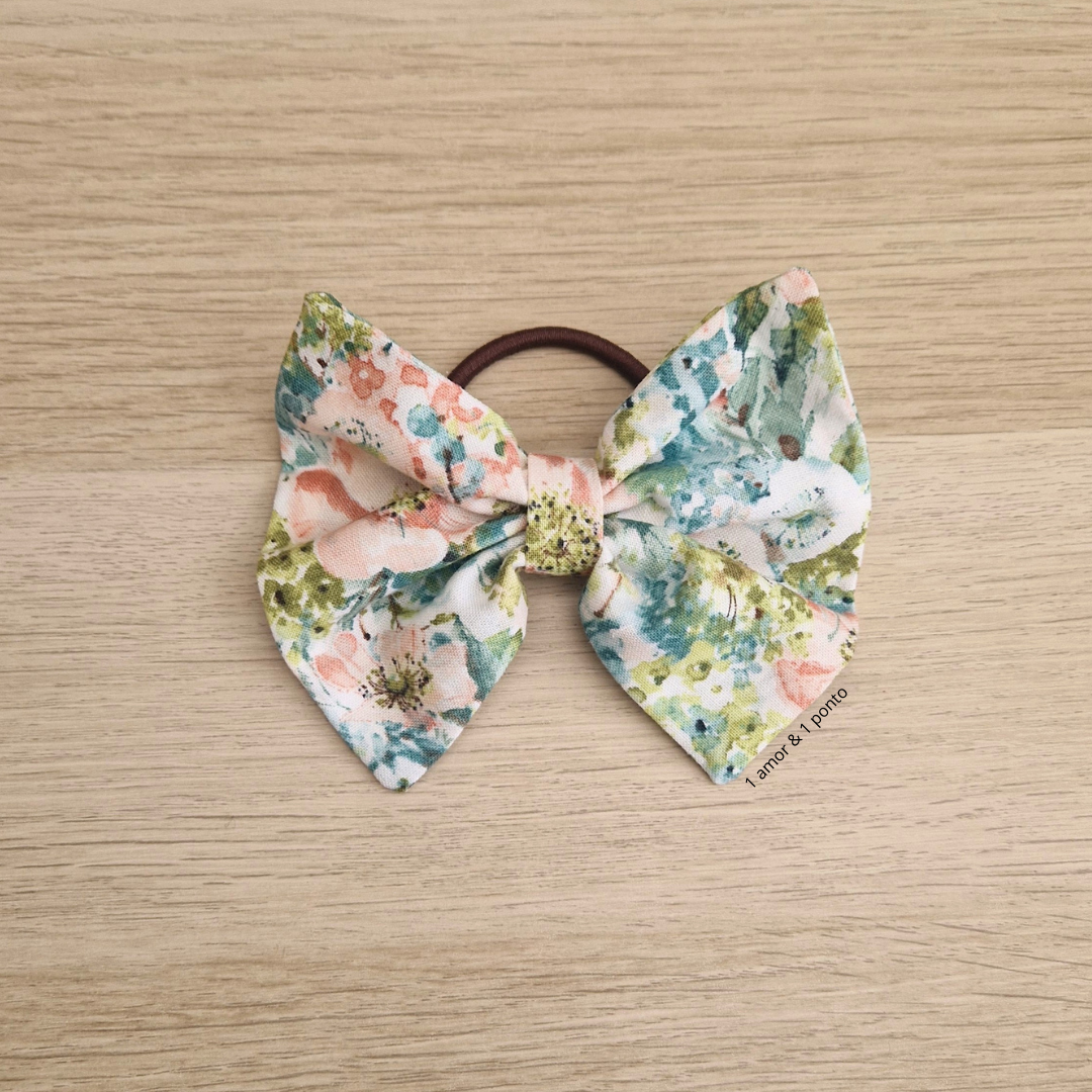 Elástico de cabelo com laço floral em tecido sobre superfície de madeira