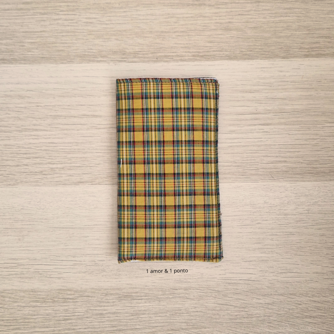 Guardanapo xadrez amarelo azul vermelho sobre mesa de madeira clara