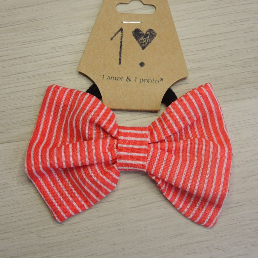 Laço vermelho às riscas brancas com etiqueta castanha marcada 