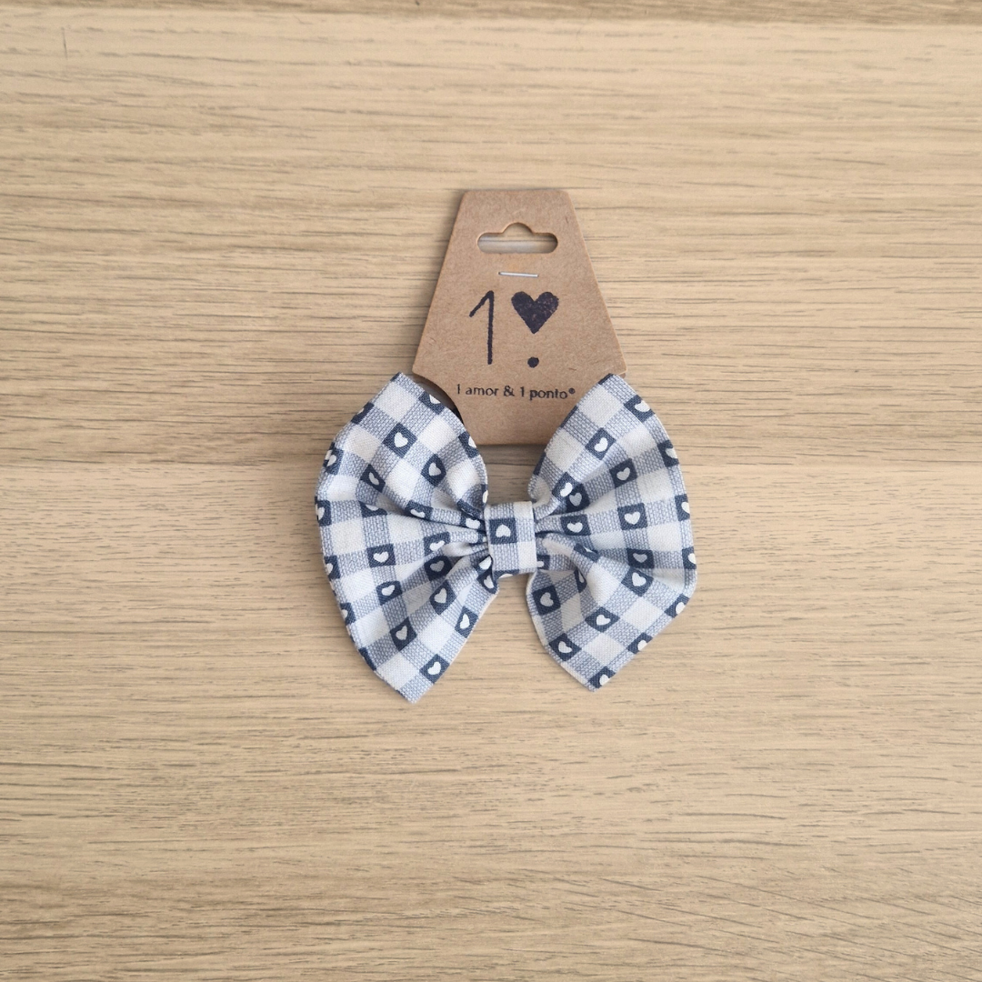 Laço para cabelo xadrez branco e azul em cartão sobre madeira clara