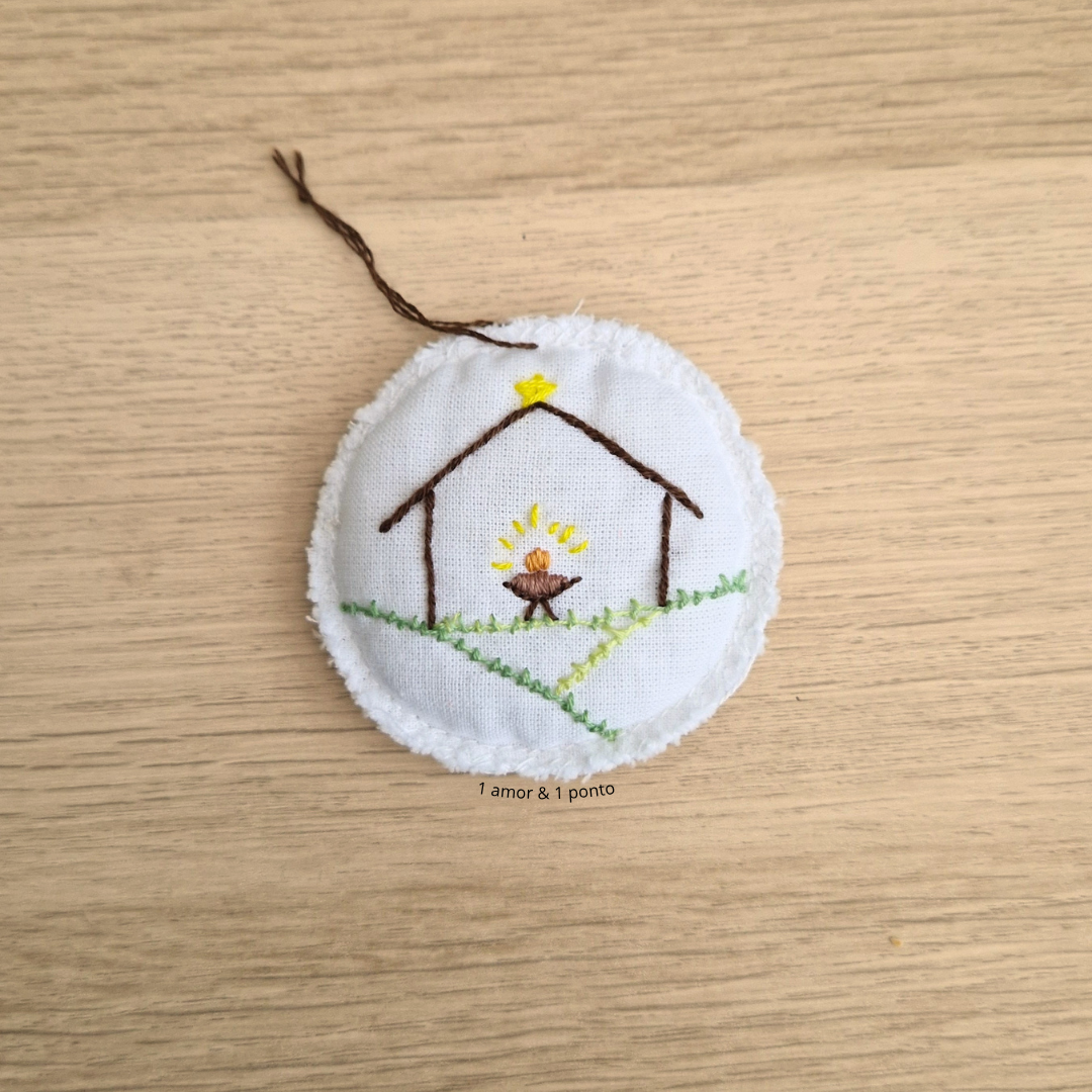 Ornamento redondo branco com bordado de presépio e estrela amarela
