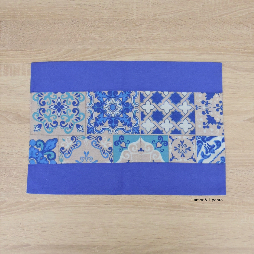 Tapete retangular azul com faixa central decorada por padrões de azulejos portugueses.