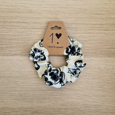 Elástico de cabelo branco com flores pretas e etiqueta marrom com texto