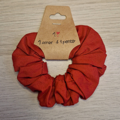 Scrunchie vermelho com etiqueta de cartão castanho