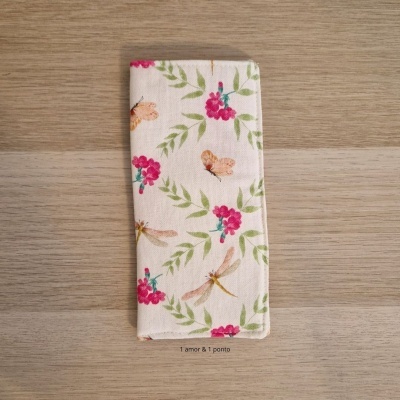 Carteira tecido padrão floral e libélulas sobre fundo madeira