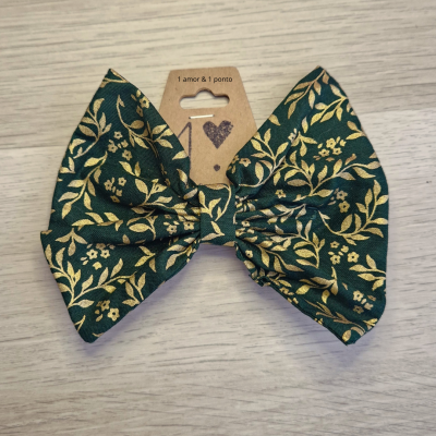 Laço de tecido verde escuro com padrão dourado e cartão castanho com escrita e coração