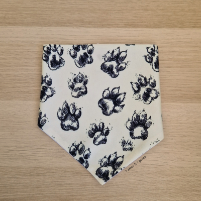 Bandana branca com pegadas de patas pretas sobre madeira clara