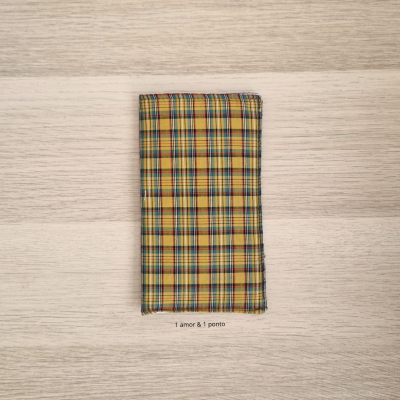 Guardanapo xadrez amarelo azul vermelho sobre mesa de madeira clara