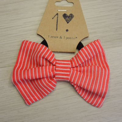 Laço vermelho às riscas brancas com etiqueta castanha marcada 