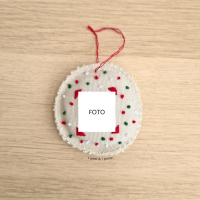 Ornamento de tecido redondo com detalhes bordados e espaço para foto
