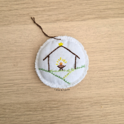 Ornamento redondo branco com bordado de presépio e estrela amarela