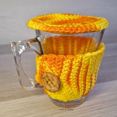 Caneca de vidro com capa de croché laranja e amarelo e botão de madeira