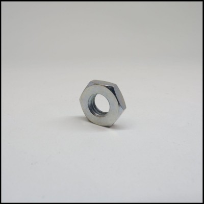 Porca metálica hexagonal prateada numa superfície branca