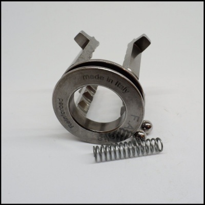 peça metálica com mola helicoidal e esferas sobre fundo branco