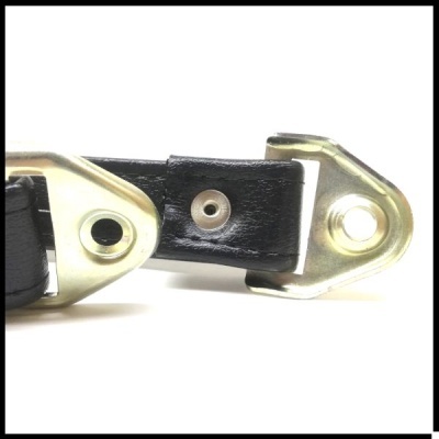 Peça de couro preto com elementos metálicos dourados e rebites