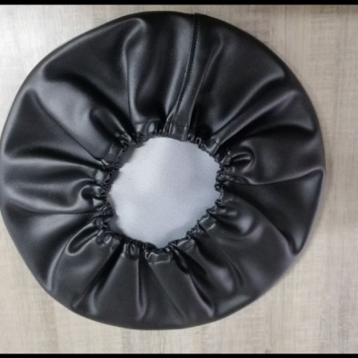 Touca ou capa preta de material liso e brilhante com faixa elástica franzida
