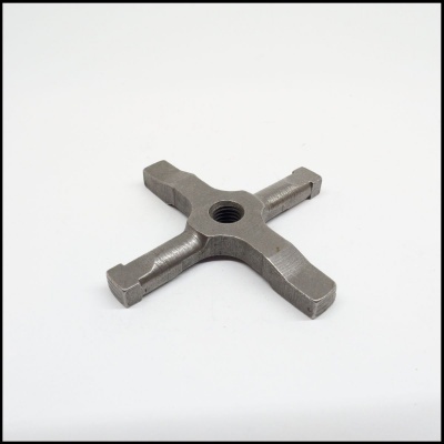 Peça metálica cinzenta em forma de cruz com orifício roscado no centro