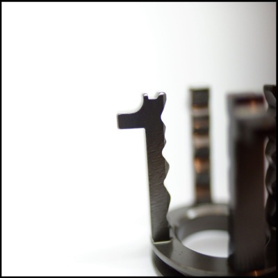 Peça metálica com ranhuras e recortes em close-up