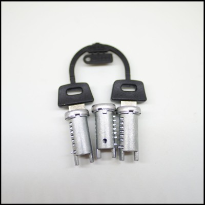 Três pinos metálicos prateados ligados por fio preto sobre fundo branco