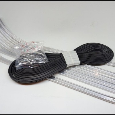 Tiras transparentes, faixa de borracha preta e saco de parafusos sobre superfície branca