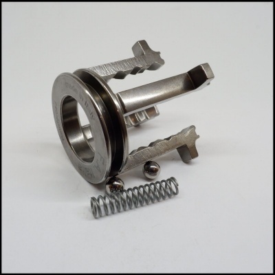 Peças metálicas pequenas com mola e esferas sobre fundo branco