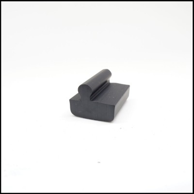 Peça preta de borracha com formato irregular sobre fundo branco