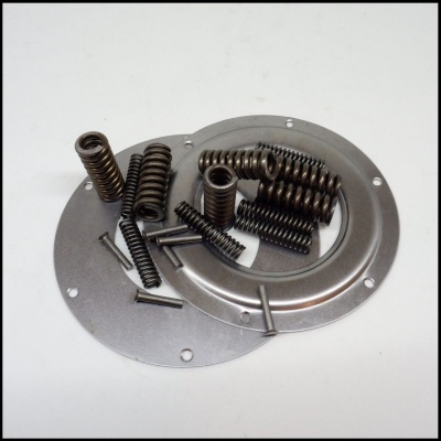 Placas metálicas circulares prateadas com molas e pinos sobre superfície branca