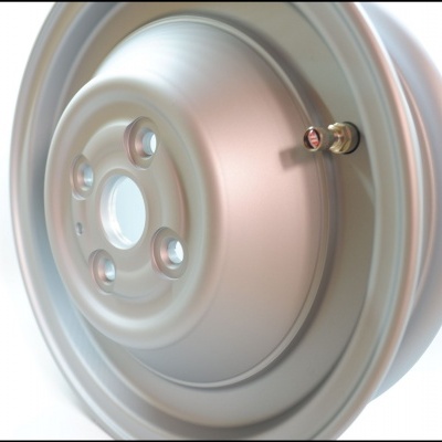 Jante metálica cinza prateada com cinco orifícios para parafusos e válvula de ar