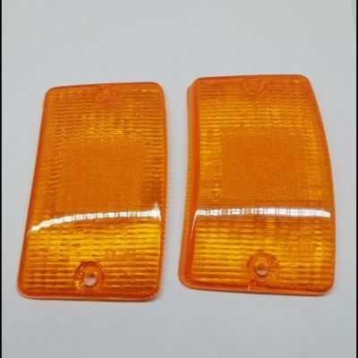 Duas tampas de vidro laranja translúcido com textura, sobre fundo branco