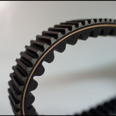 Correia dentada preta de borracha com textura rugosa e camada castanha interior