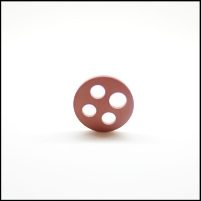 Botão castanho redondo com quatro orifícios sobre fundo branco