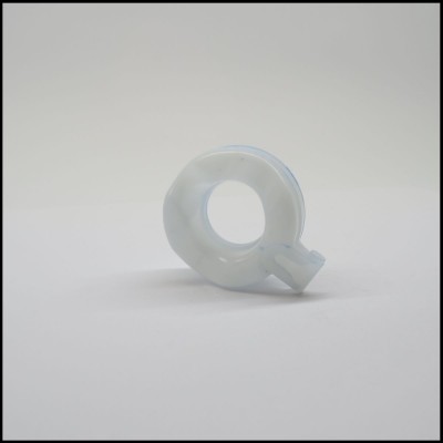 Objeto de plástico translúcido em forma de letra Q sobre fundo branco