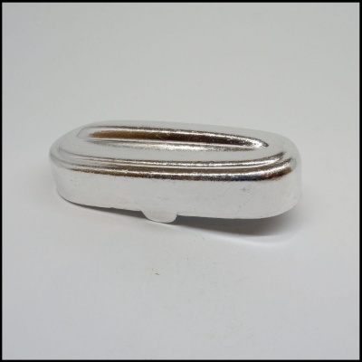 Peça metálica prateada de formato oval longo