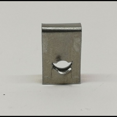 Peça metálica prateada com recorte em forma de boca