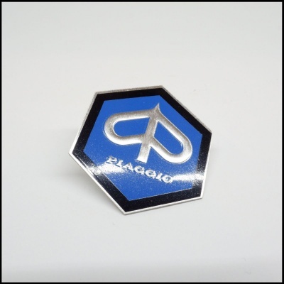 Emblema hexagonal azul e prateado com logo Piaggio