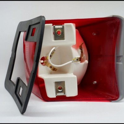 Farol traseiro de veículo com lente vermelha e branca e moldura preta