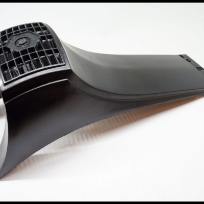 Peça plástica preta com superfície lisa e grelha na extremidade