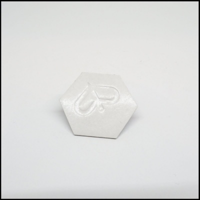Peça hexagonal branca com símbolo em relevo de gota e letra P