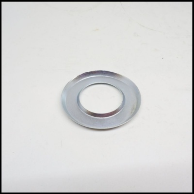 Arruela metálica circular prateada sobre superfície branca